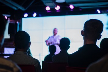 immagine che ritrae uno speaker su palco difronte a una platea