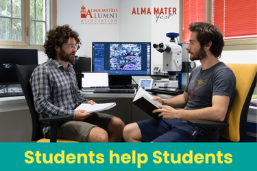 Due studenti si scambiano consigli in un laboratorio informatico