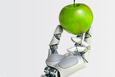 Mano robotica che regge una mela